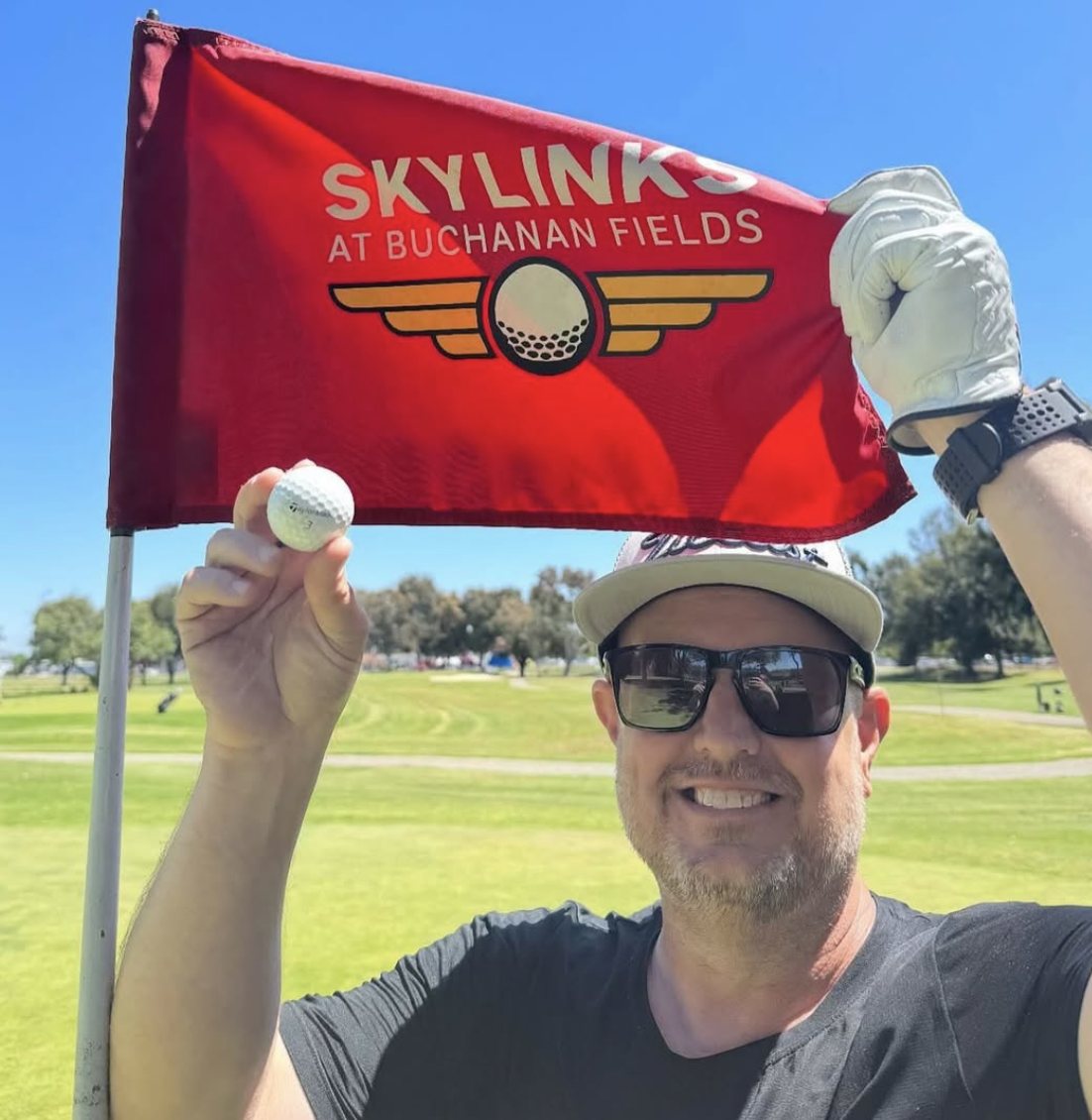 Celebrating a hole in one with the Skylinks flag